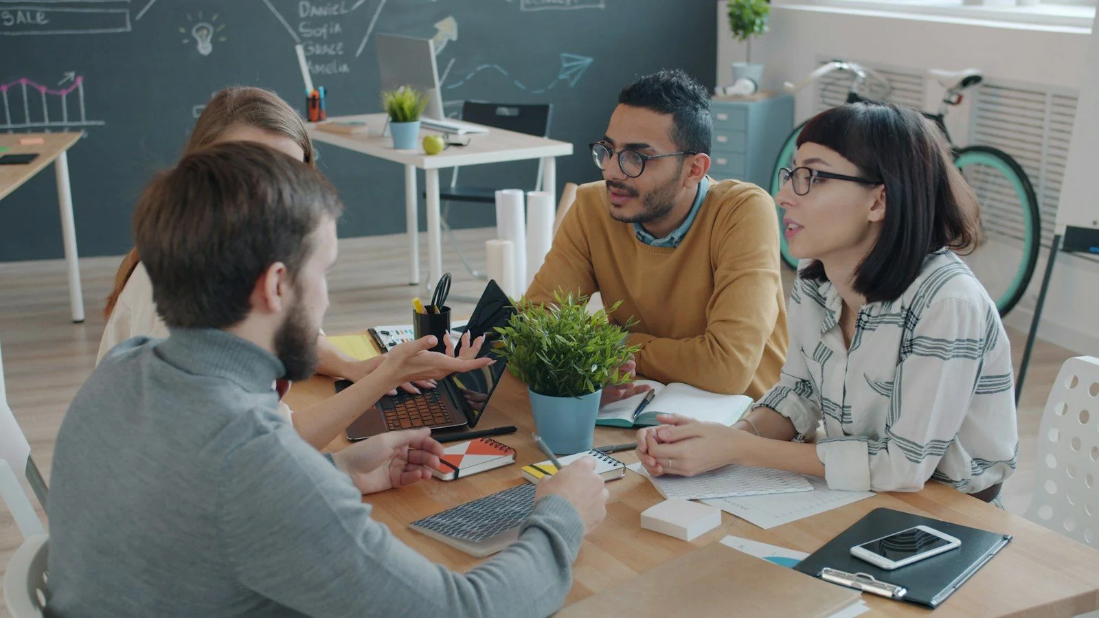 A small team working through a plan together around a table
